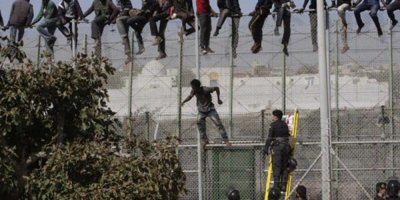 Migrantes subidos a la valla fronteriza con  España 