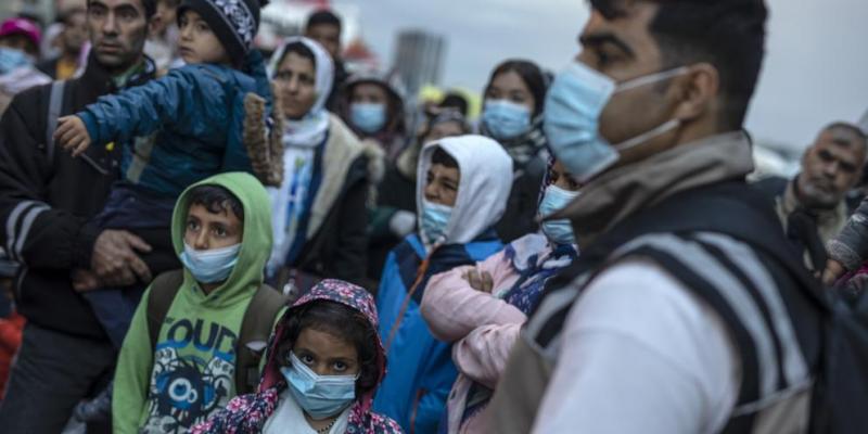 Refugiados y migrantes llevan mascarillas para prevenir la propagación del coronavirus. Grecia ha empezado a trasladar personas del campo de refugiados de Moria, que se encuentra en la isla de Lesbos, al continente. Moria tiene capacidad para 3.000 personas, pero alberga a casi 20.000. (Petros Giannakouris / AP)