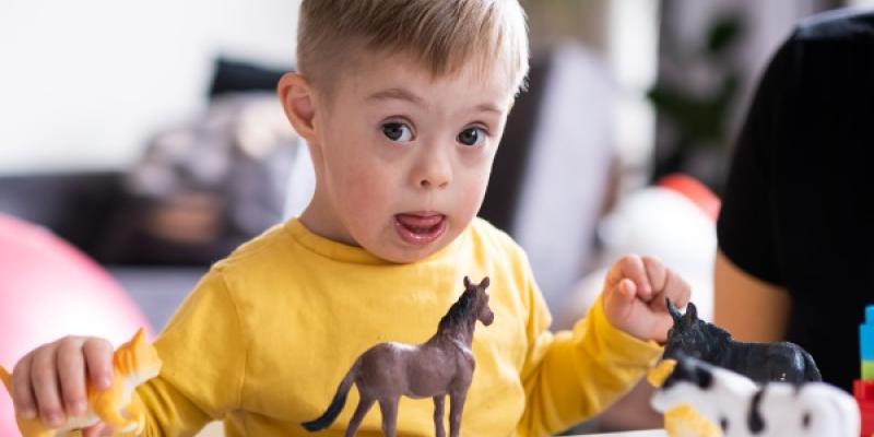 niño feliz que vive con síndrome de Down jugando con juguetes de animales en casa. Desarrollando la creatividad, mostrando expresiones faciales / Envato niño feliz que vive con síndrome de Down jugando con juguetes de animales en casa. Desarrollando la creatividad, mostrando expresiones faciales