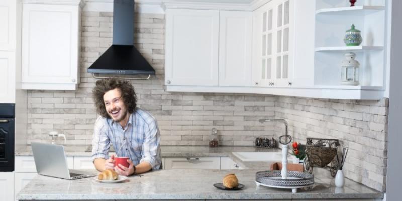 Hombre con discapacidad intelectual desayunando en la cocina| Foto de 123rf/myvisuals Hombre con discapacidad intelectual desayunando en la cocina