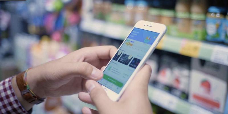 Donaciones de alimentos a través de la app Nadie sin su ración diaria / Fuente: Simplr.io Imagen de una persona con un teléfono móvil realizando donaciones de alimentos