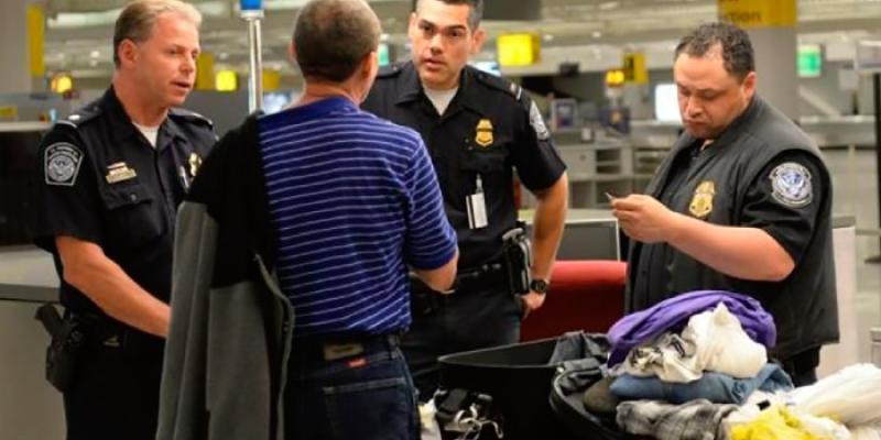 Restricciones migratorias Policías revisando una maleta