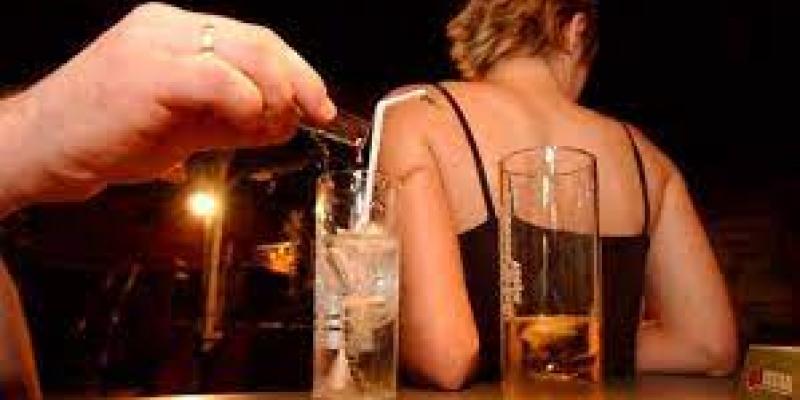 Abusos sexuales por drogas Persona echando droga en la copa de una mujer