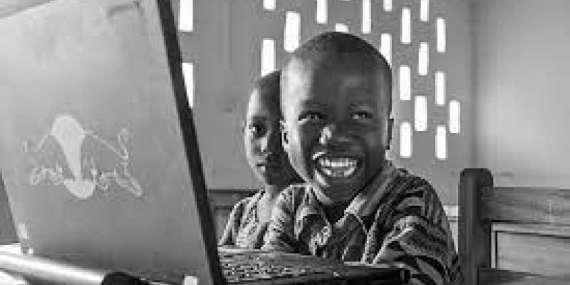 Imagen de un niño en Ghana con un ordenador portátil/nascoict Un programa para mejorar la calidad educativa y digital en Ghana