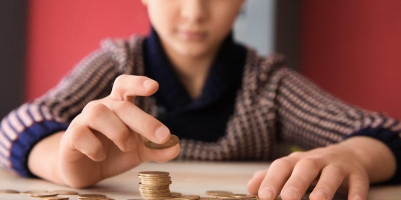 Imagen de un niño con monedas/Magisnet La paga como método financiero y educativo para los hijos