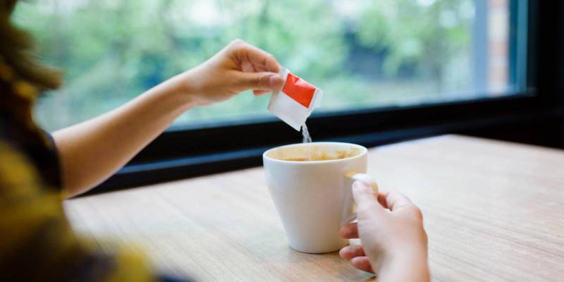Imagen de una persona echando edulcorante a su café/National Geographic La OMS desaconseja tomar edulcorantes
