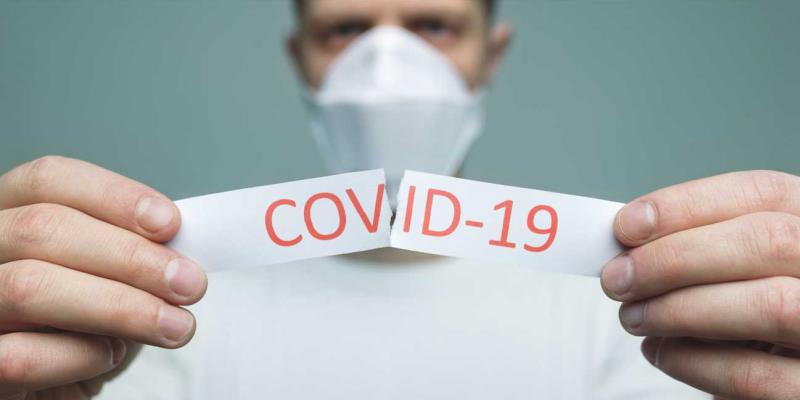 Señor rompiendo un cartel que dice 'COVID-19' / Pixabay