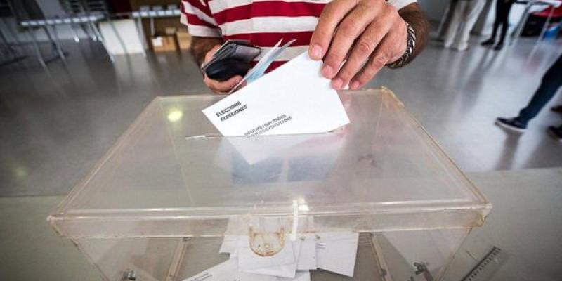 n elector deposita su voto en la urna en unas elecciones catalanas. 