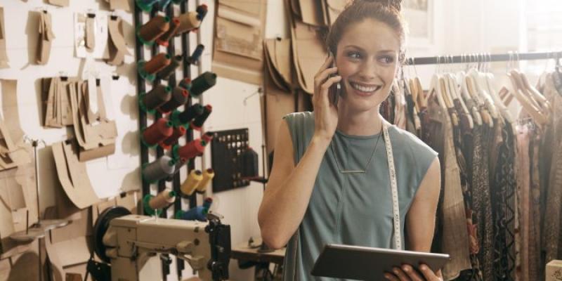 Trabajadora con una tableta en un taller de costura 