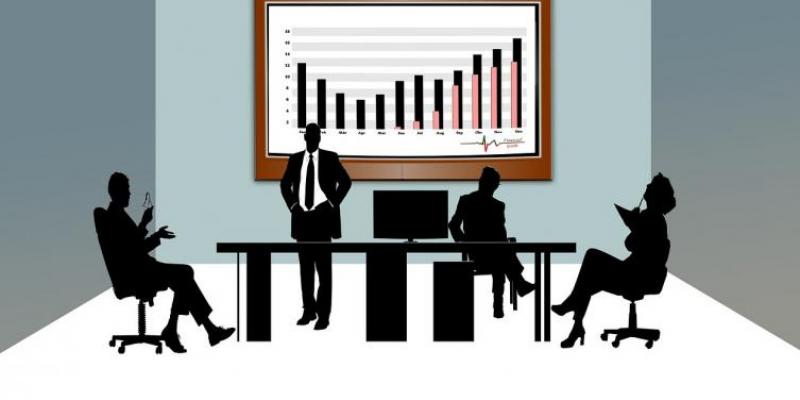 Reputación de las empresas Infografía de una reunión de empresa, mesa de trabajo con monitor con gráficas.