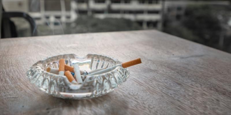 Fumar en terrazas | Foto: 123rf/bbbirdz Un cenicero con un cigarrillo humeante en una mesa de una terraza