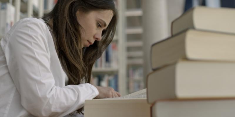 Una investigadora leyendo libros en España