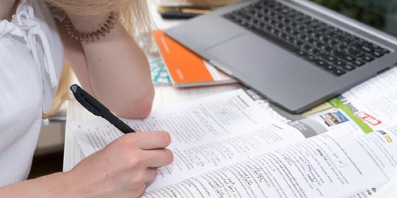 Imagen de una chica estudinado/evatoelements Linguaskill, examen de inglés adaptable
