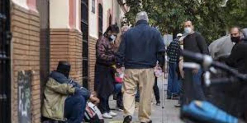 Una fila de personas espera ayuda en la calle