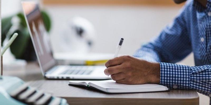 Expertos promueven la profesionalización de la lectura fácil Chico tomando apuntes frente su laptop