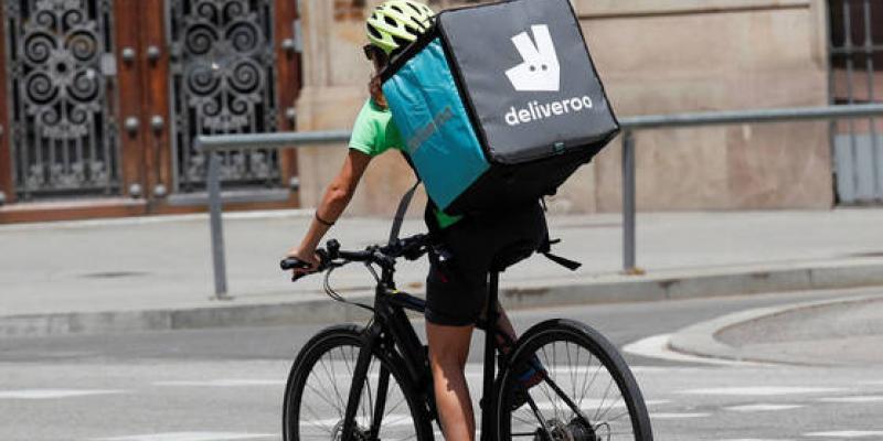 Un 'rider' pedalea con la típica mochila a la espalda 