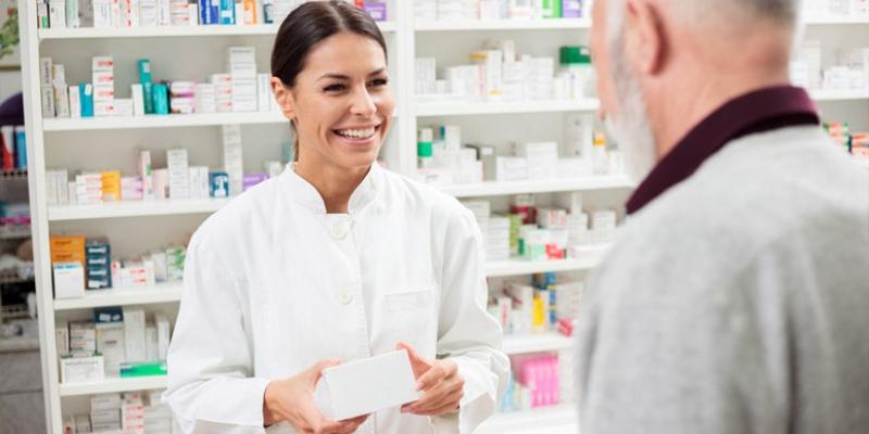 Imagen de una farmacéutica con un cliente/Consejo General de Colegios Oficiales de Farmacéuticos Día Mundial de los Farmacéuticos