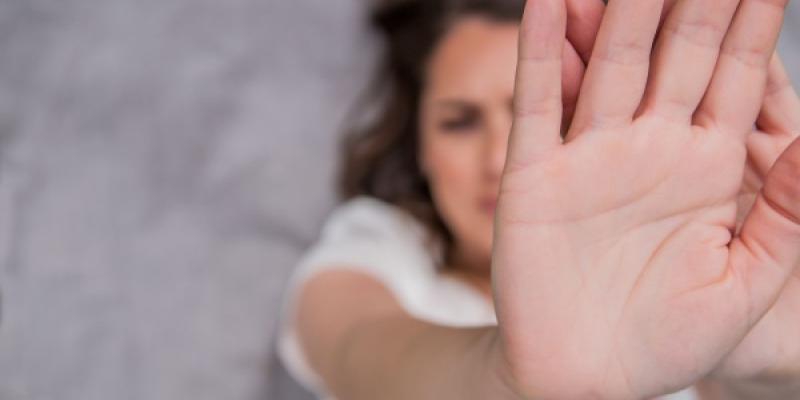 Mujer tapándose la cara con la mano