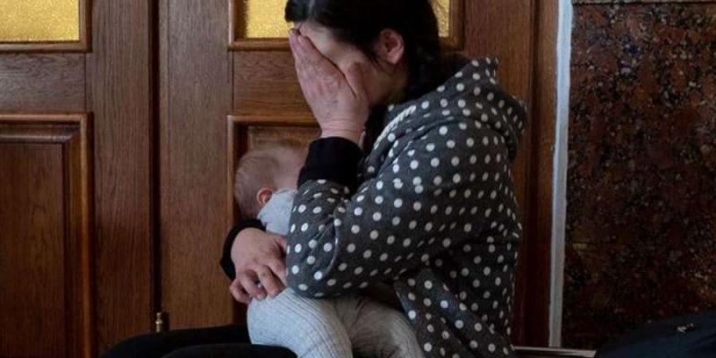 Una mujer ucraniana con su hijo espera en la estación de tren de Lviv, desde donde saldrá de su país.