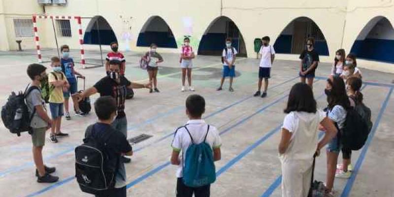 Fisioterapeutas /Región digital Chicos portan sus mochilas en la espalda y hablan en circulo con mascarilla puesta