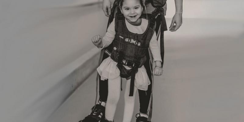 Imagen de la campaña de apoyo a la investigación del daño cerebral que muestra a una niña aprendiendo a andar / Tecnobility