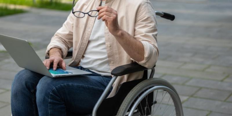 Becas para estudiantes con discapacidad | Foto de 123RF/zinkevych Un estudiante en silla de ruedas consulta su ordenador