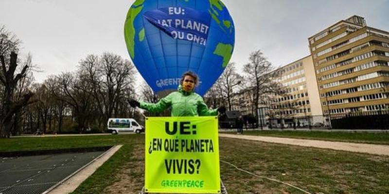 Activista de Greenpeace despliega una pancarta con el lema 'UE: ¿en qué planeta vivís?', delante del globo aerostático