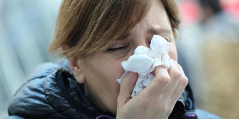 Señora sonándose los mocos por la gripe