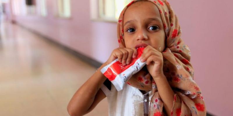 Imagen de una niña con un alimento/elDiarioSolidario La hambruna, concepto y medidas