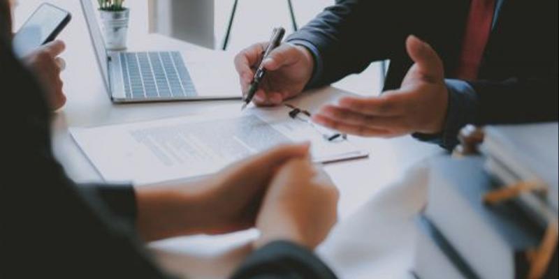 SHUTTERSTOCK Manos de dos personas hablando sobre el impuesto de plusvalía