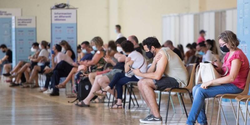 Una cola de personas en una sala del centro de vacunación masiva, instalado en la Fira de Cornellà (Barcelona)