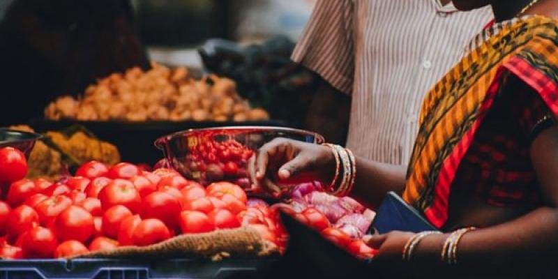 Mujer comprando tomates en el mercado