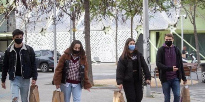 Jóvenes en la calle con mascarillas