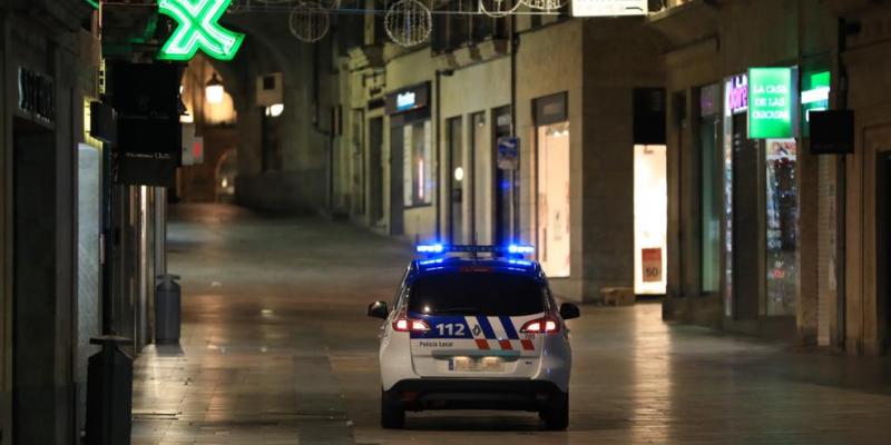 Justificar los desplazamientos Coche de la policía patrullando por las calles vacías ante el toque de queda