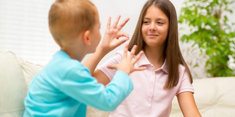 Dos niños comunicándose en lengua de signos