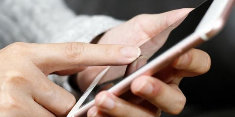 Accesibilidad en materia digital / Canva Mano de una persona con un teléfono móvil