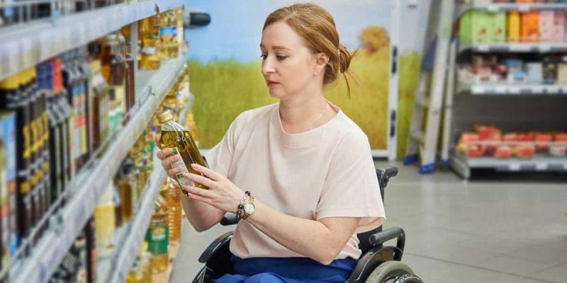 Imagen de una persona en silla de ruedas comprando en un super/La Vanguardia Más de la mitad de los españoles fomentan las marcas inclusivas