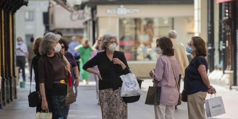 Señoras hablando con mascarillas en la calle