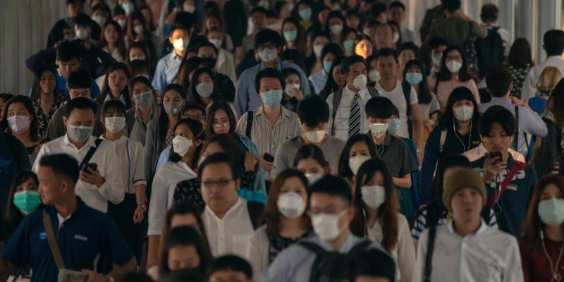 Cientos de personas con mascarillas en una ciudad China.