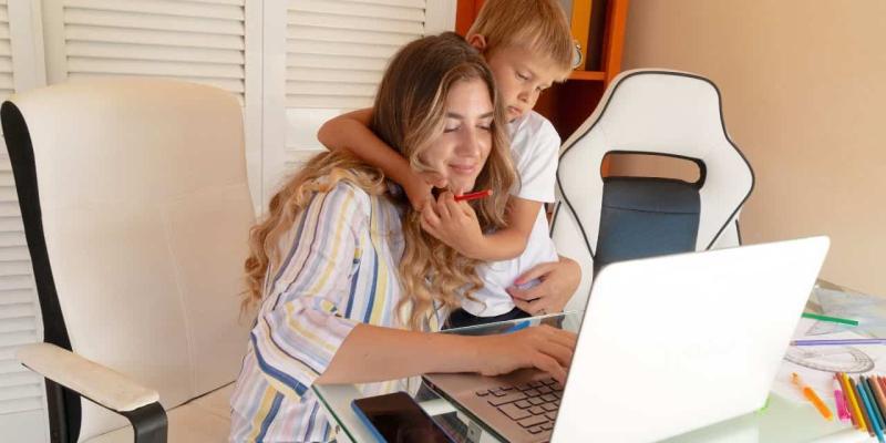 Imagen de una madre con su hijo teletrabajando/Linkedin Maternidad y empleo