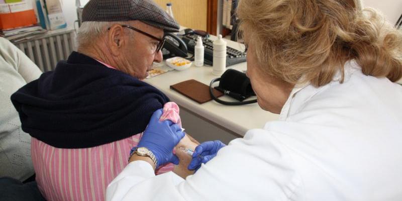Los médicos de familia apoyan la vacunación contra la gripe/ SEMG Médicos de familia atendiendo a un paciente