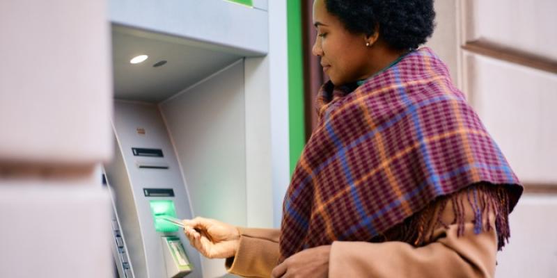 Mujer sacando dinero de la nómina - Foto: Envato Elements Mujer sacando dinero de un cajero