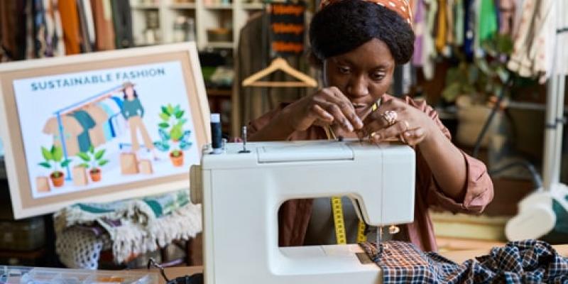 Imagen de una chica con una máquina de coser/Envatoelements Moda sostenible y sus beneficios