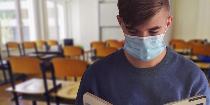 Chico en un aula con mascarilla