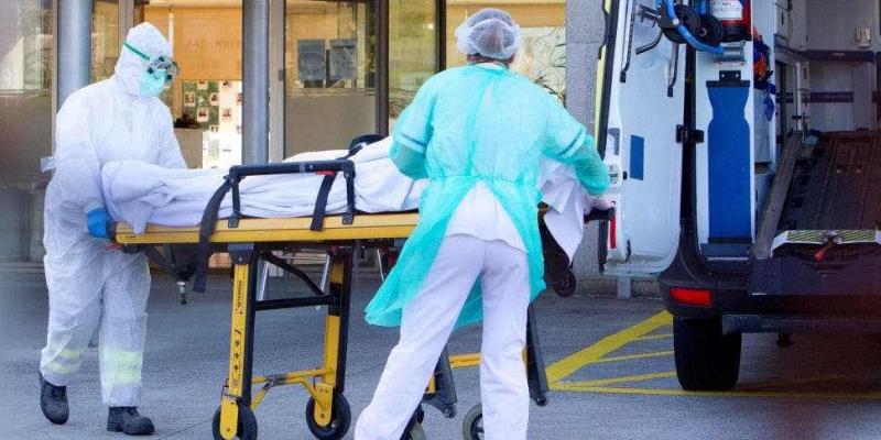 Las muertes por coronavirus se duplicarán en España a final de año Sanitarios con enfermo de coronavirus en una camilla