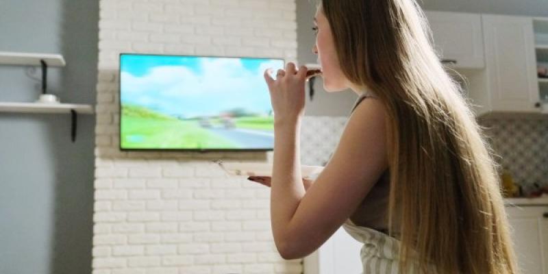 Mujer consumiendo publicidad en su televisor