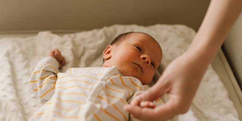 Un bebé agarra la mano de su madre | Foto de 123rf/nastyaofly Un bebé agarra la mano de su madre