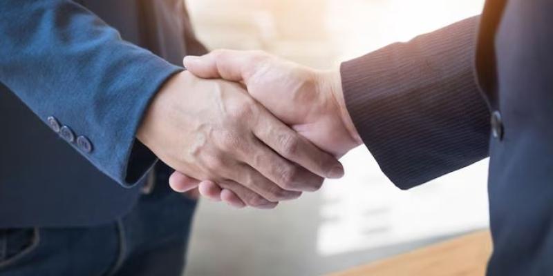 Dos personas cerrando un negocio con un apretón de manos