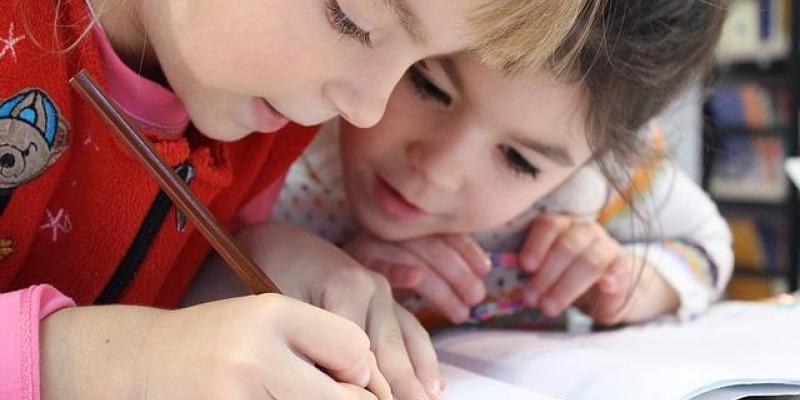 Dos niñas escriben en un cuadernos 