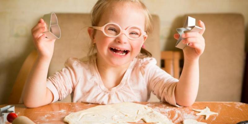 Juguetes recomendados para niños con síndrome de Down / Webconsultas Niña con síndrome de Down riendo y jugando